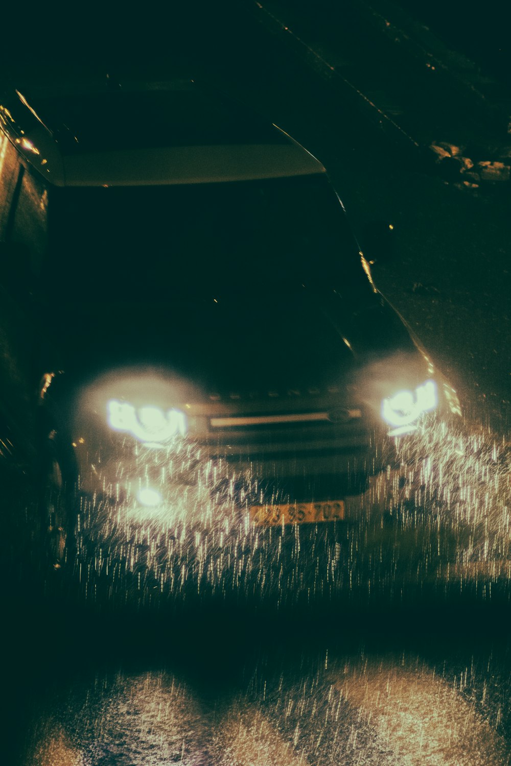 a car driving down a wet street at night