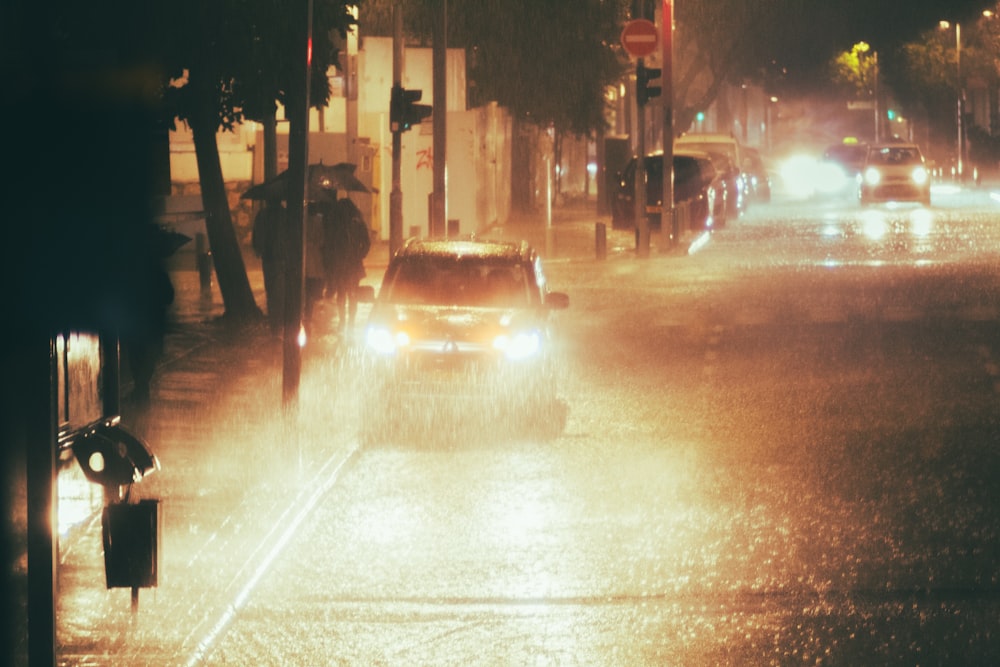 a car driving down a rain soaked street at night