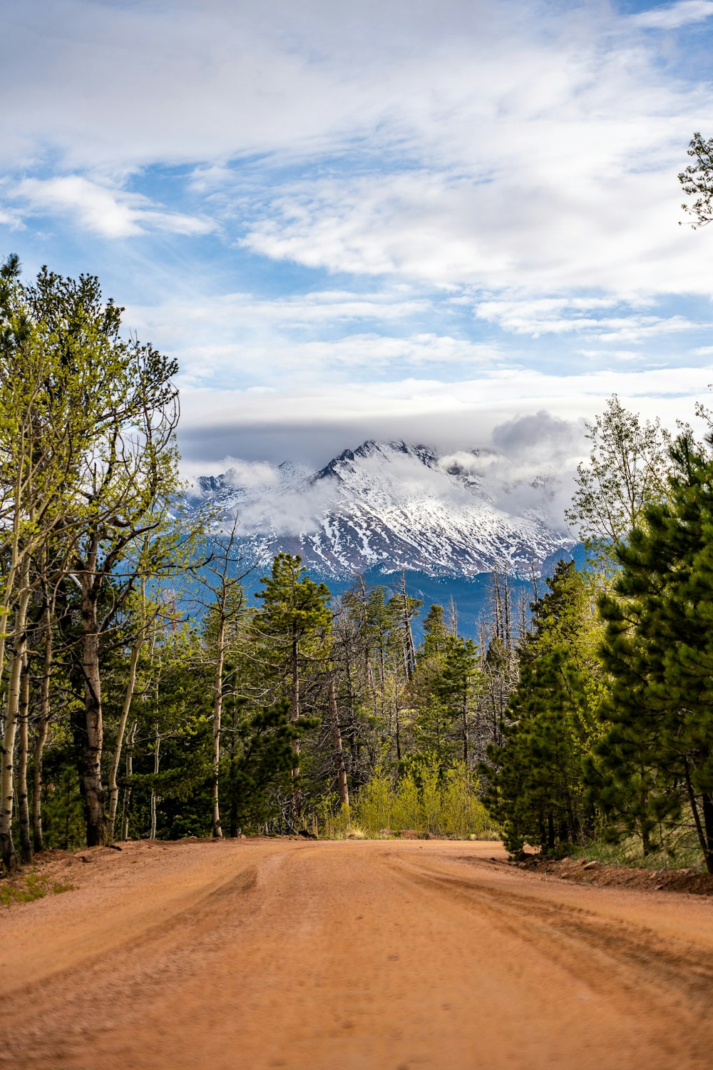 a dirt road with a mountain in the background