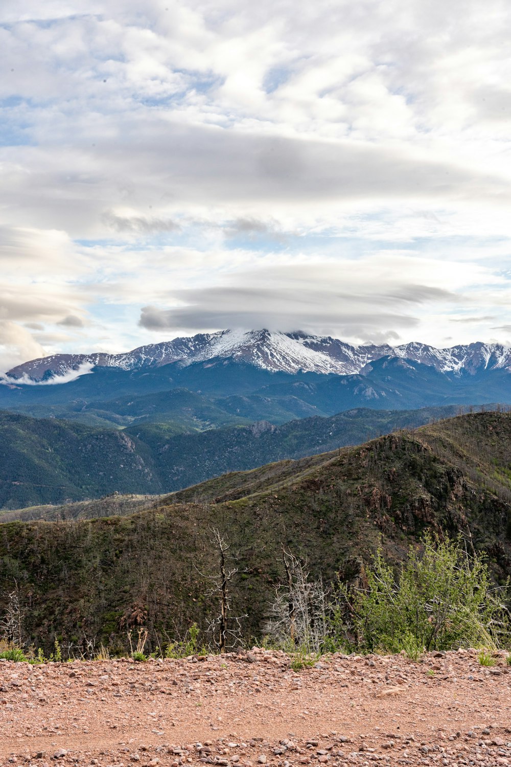 a view of a mountain range with snow capped mountains in the distance
