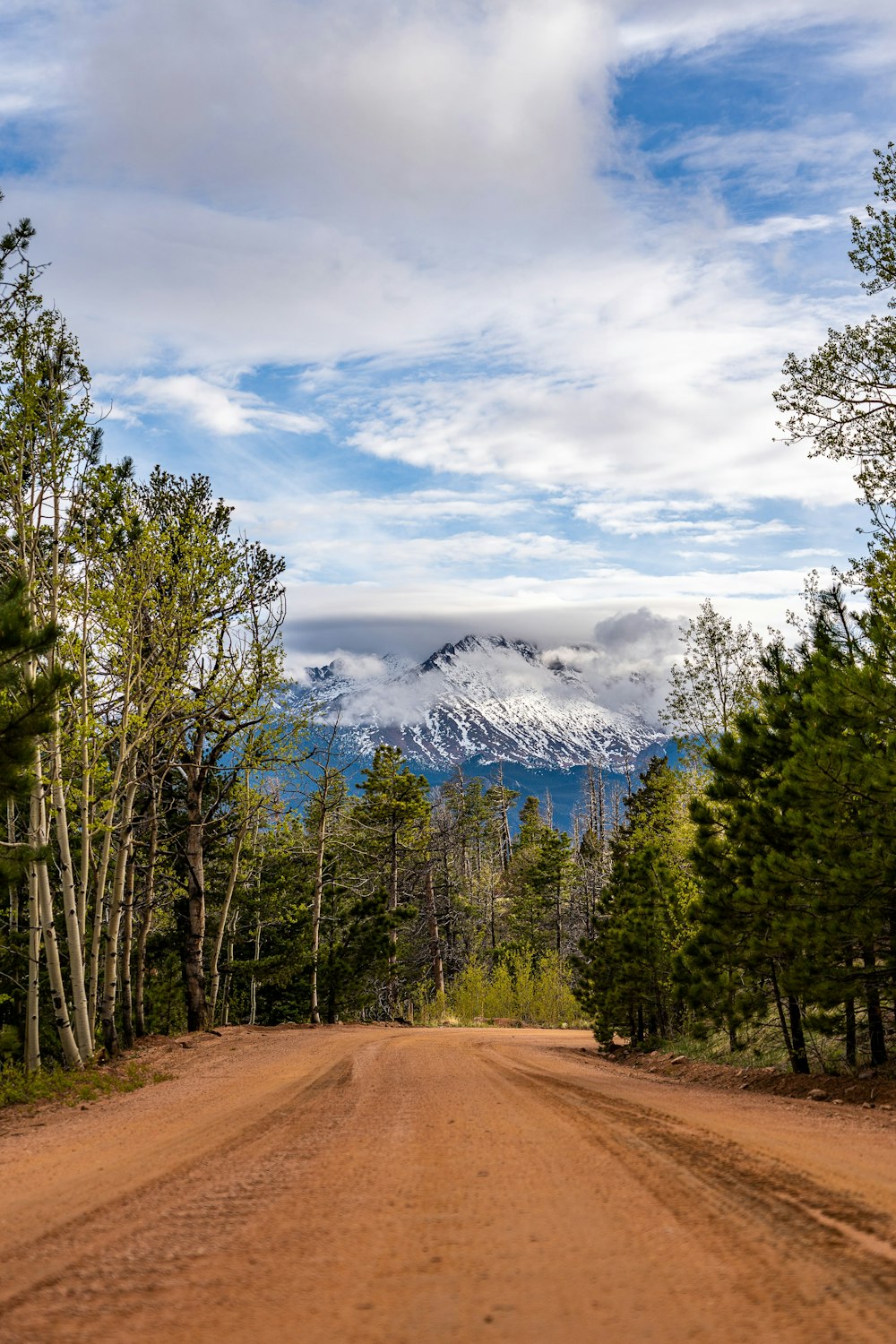 a dirt road with a mountain in the background