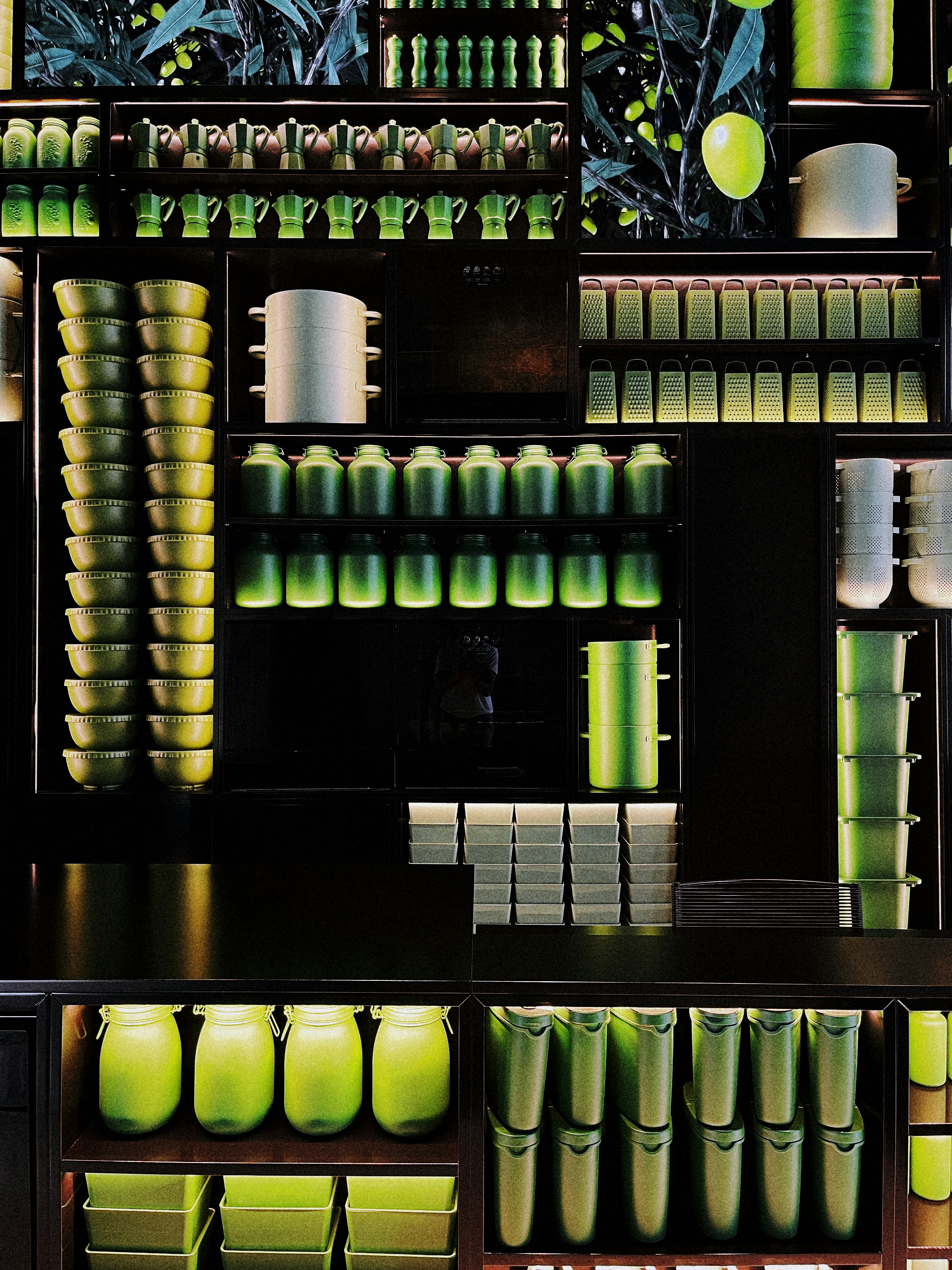 a shelf filled with lots of green vases