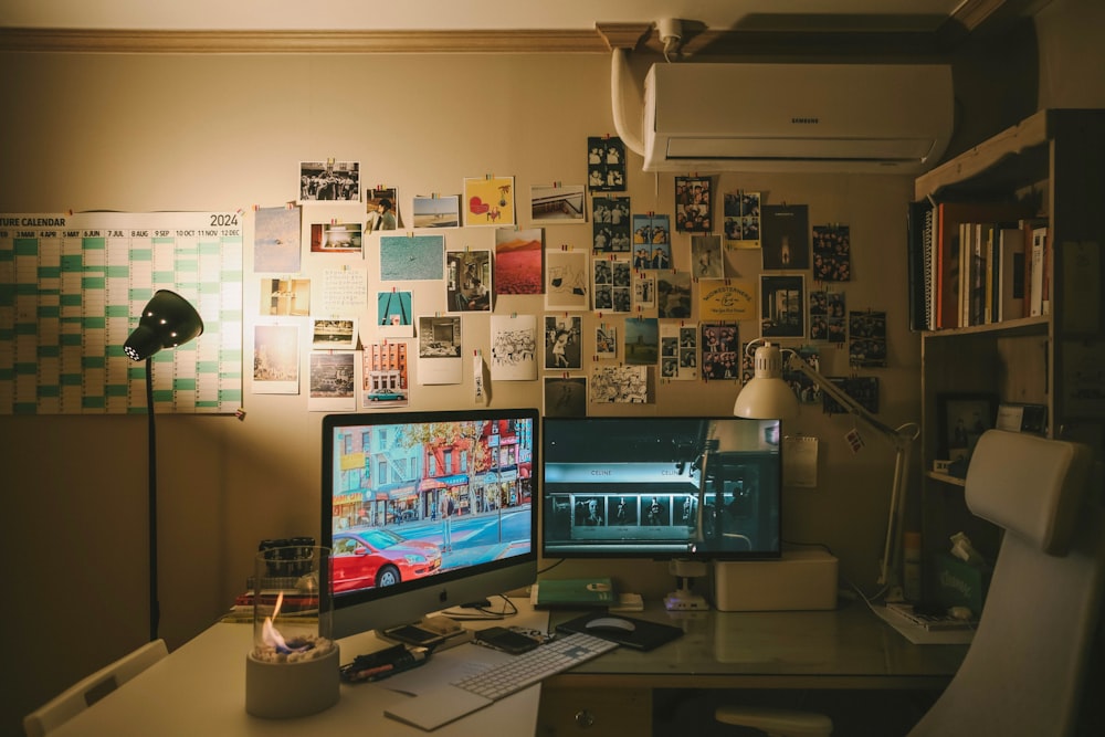 a computer desk with two monitors and a lamp