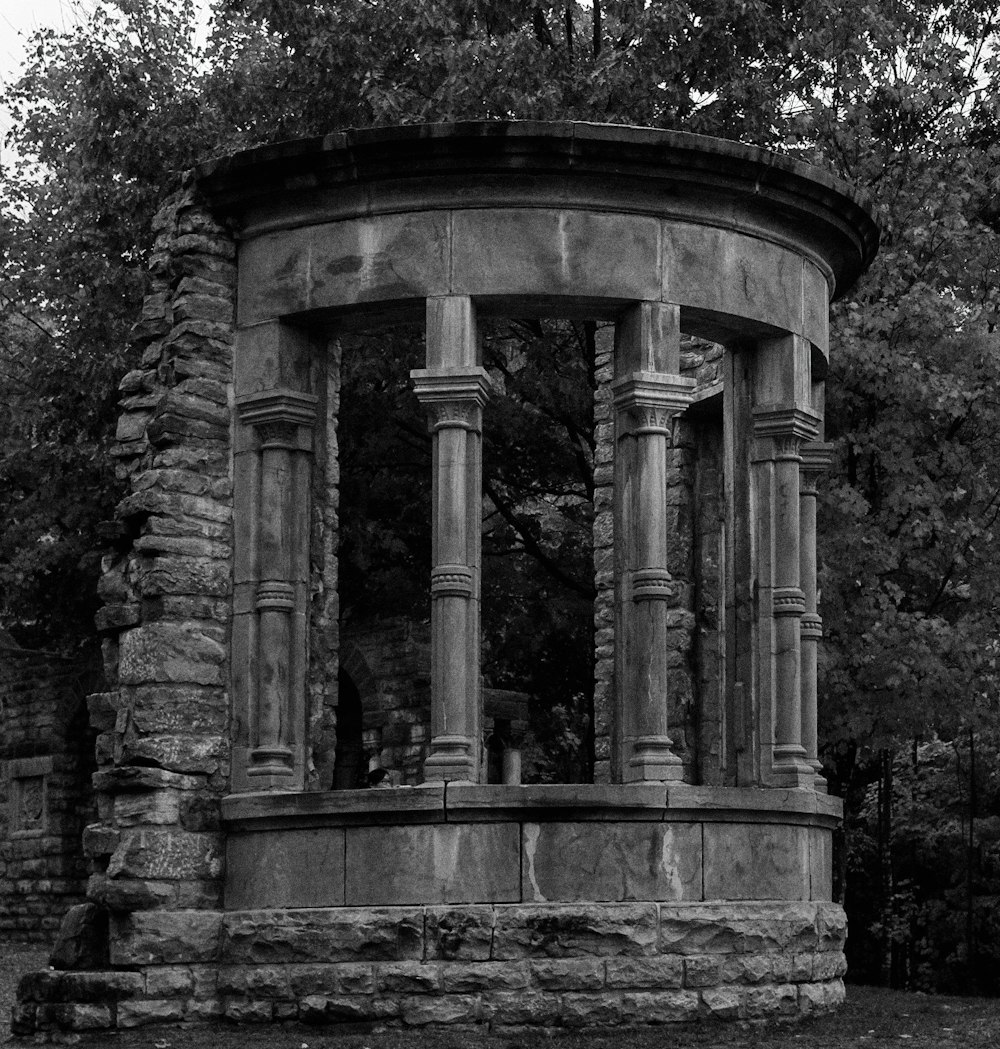 a black and white photo of a stone gazebo