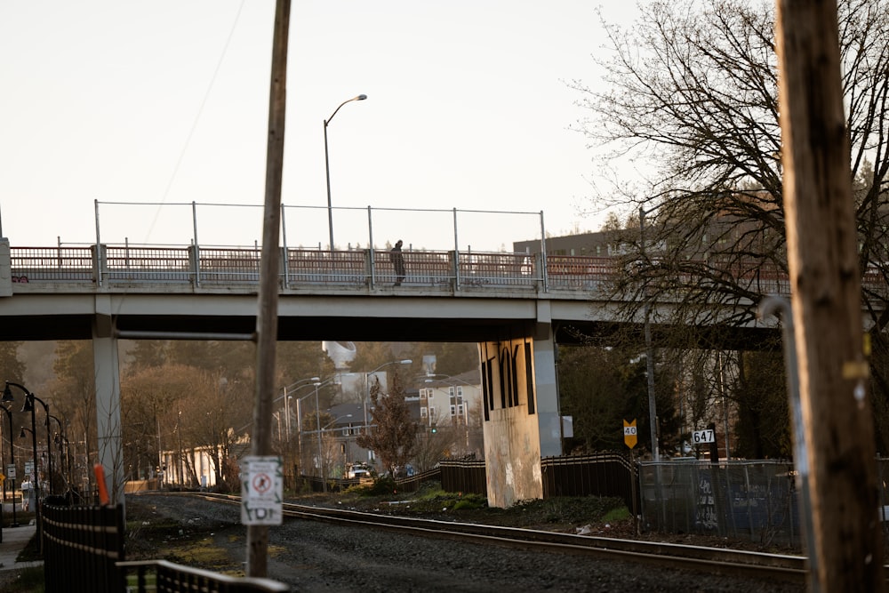 a bridge over a train track with people walking on it