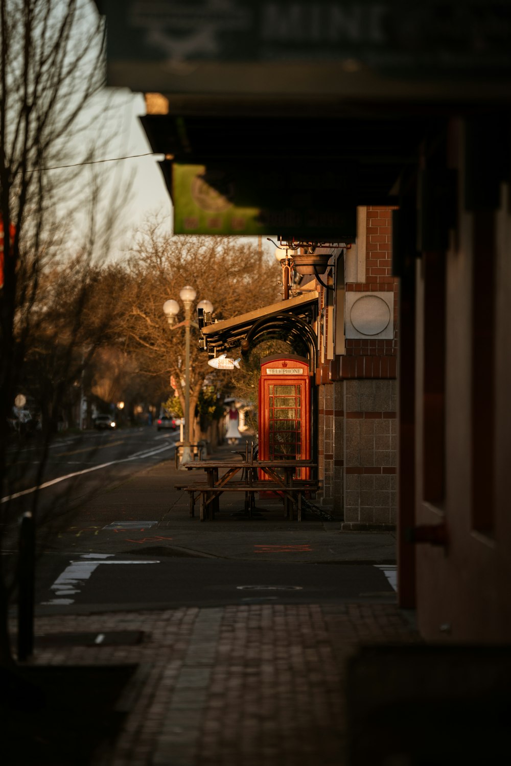a red phone booth sitting on the side of a road