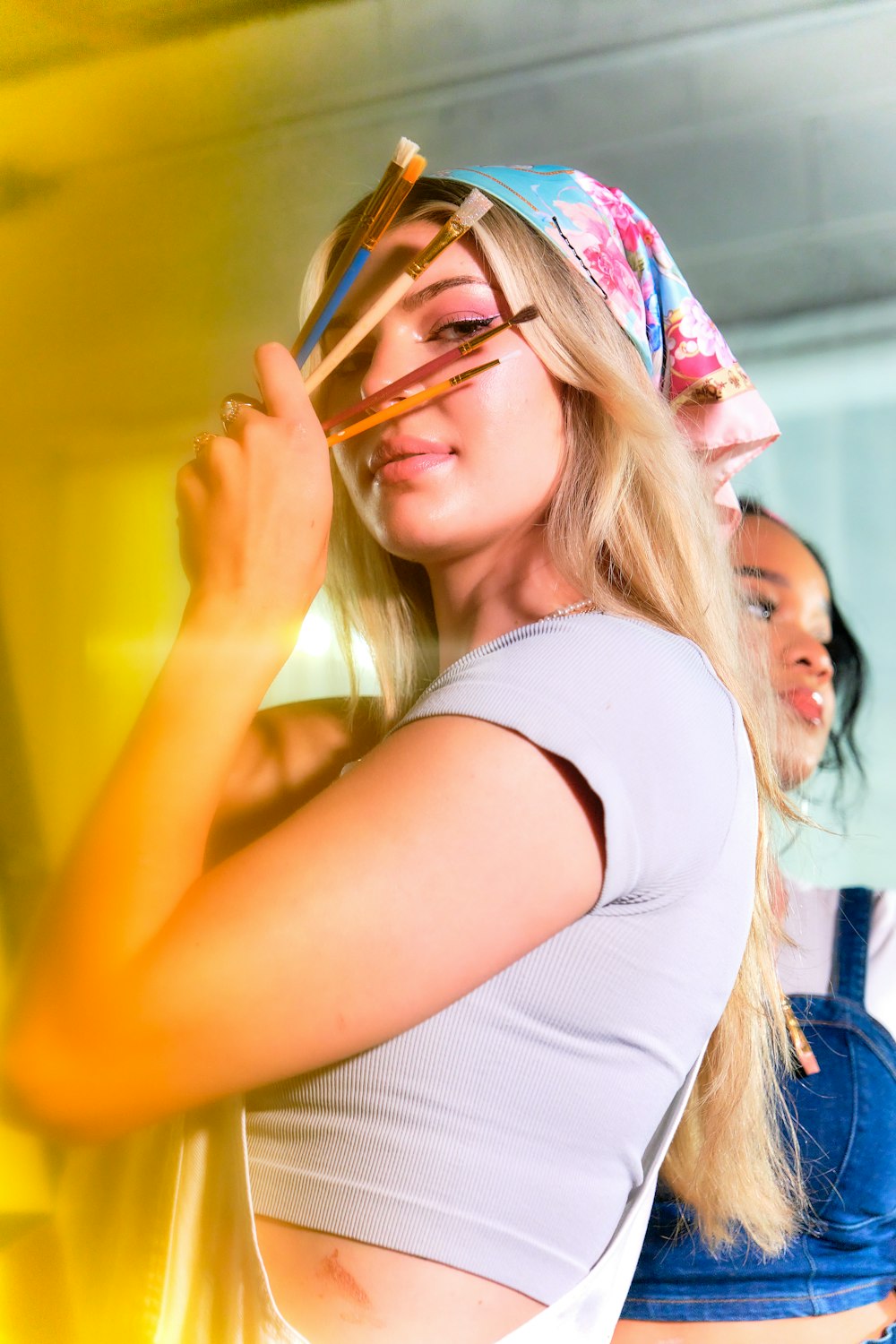 a woman wearing a bandana and holding a cell phone