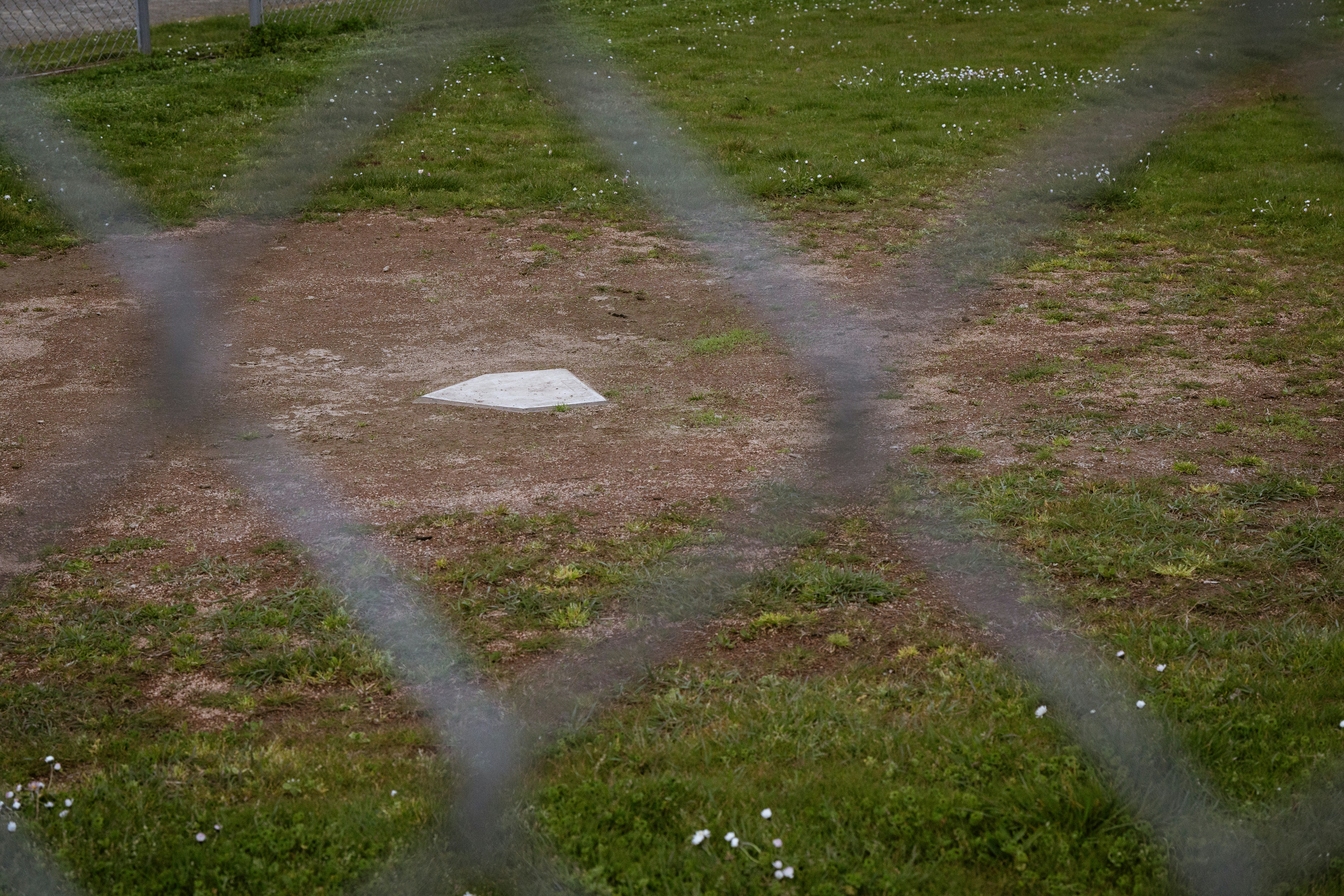 a baseball field behind a chain link fence