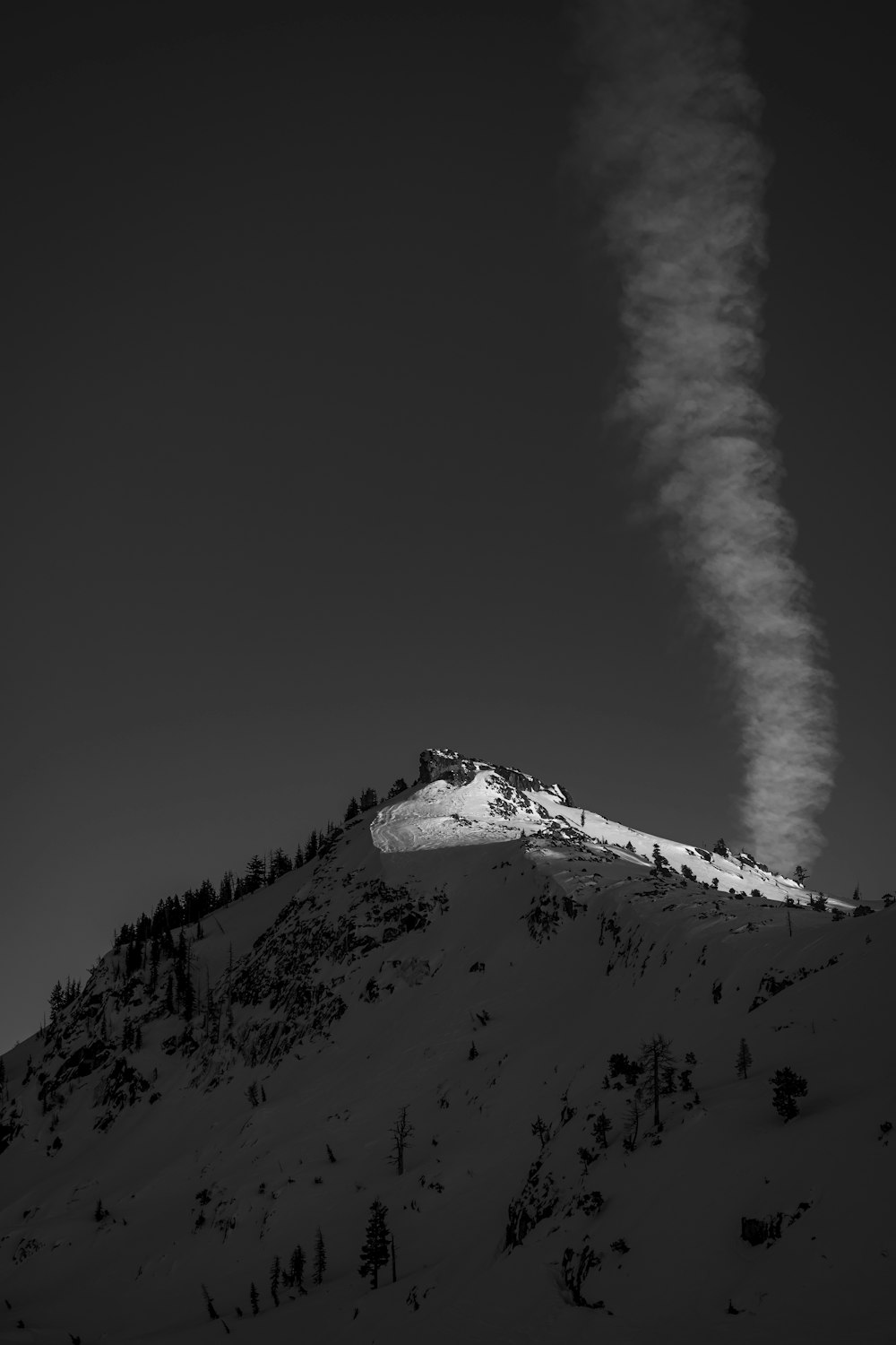 a cloud of smoke is coming from the top of a mountain