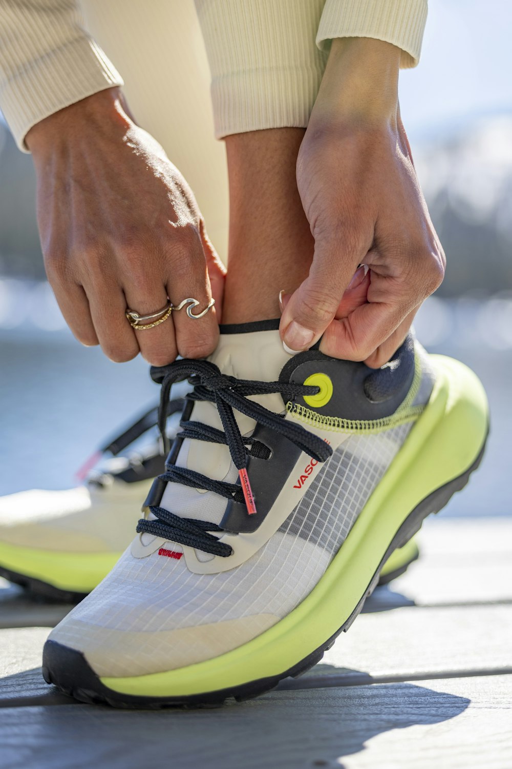 a person tying a shoelace on a tennis shoe