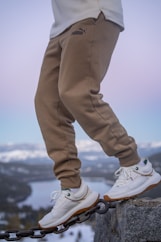 a person standing on a chain on top of a mountain