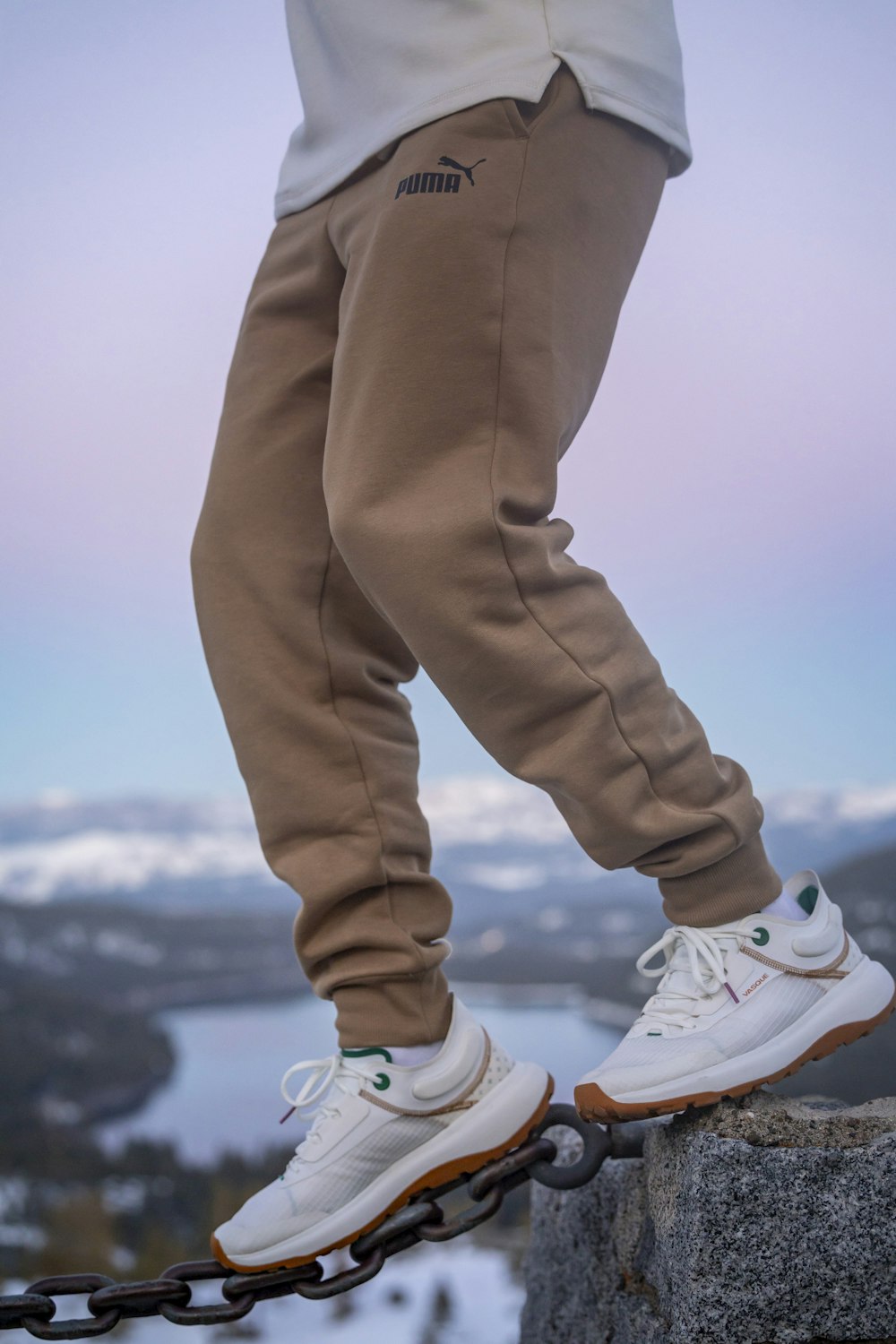 a person standing on a chain on top of a mountain