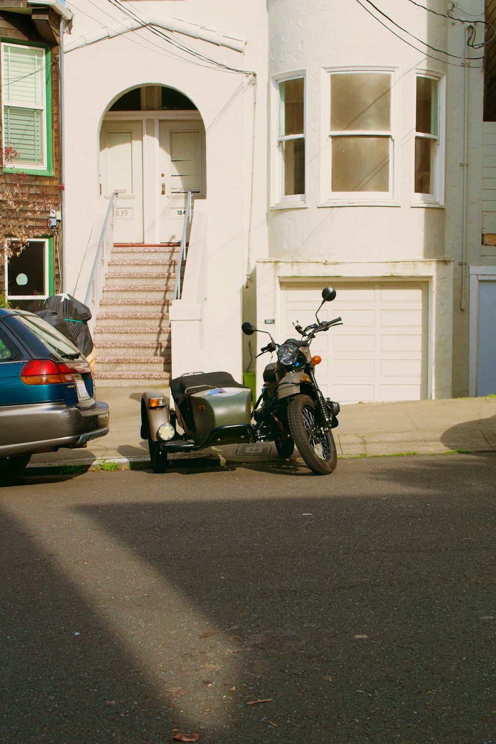 a motorcycle parked next to a car on a street