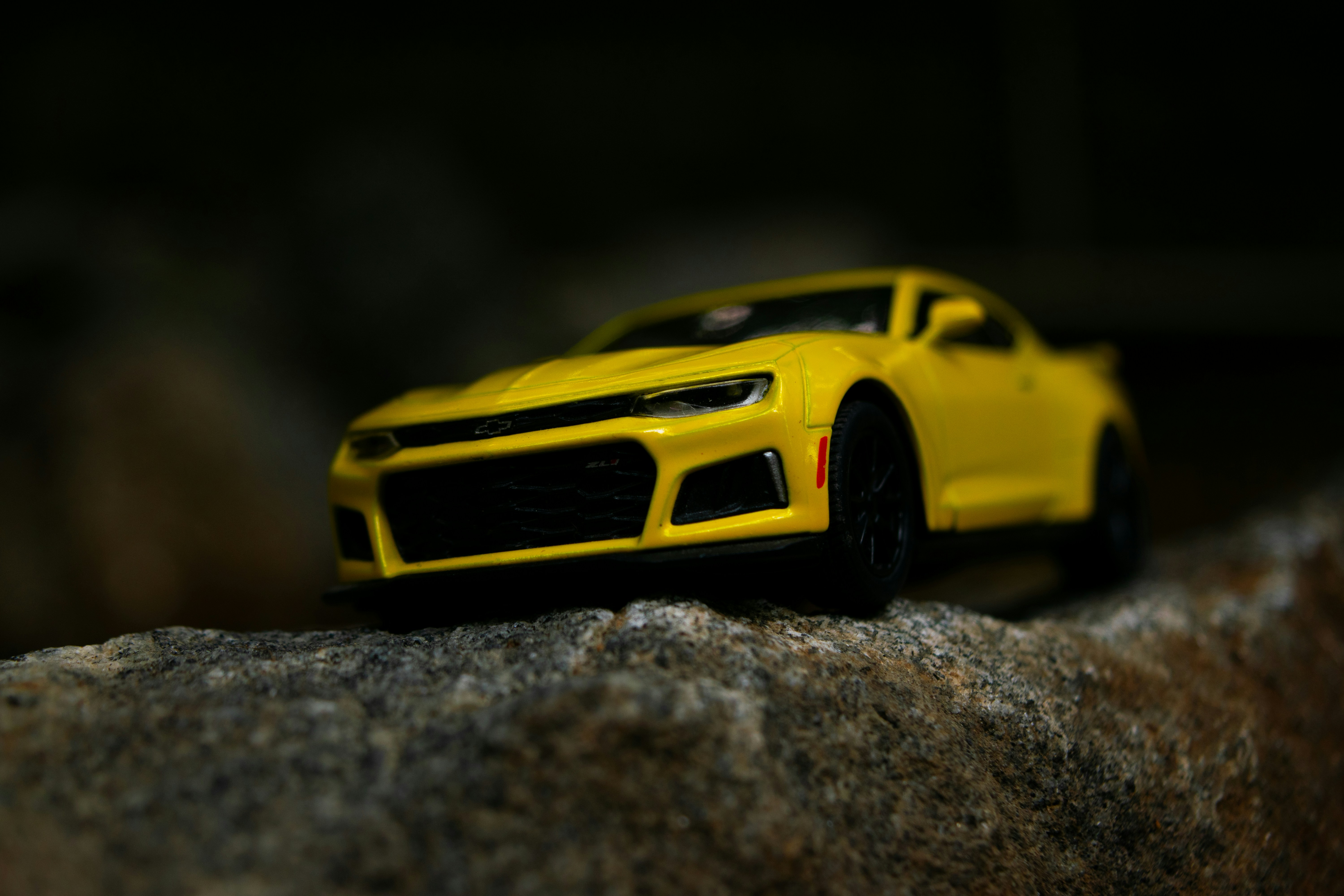 una macchinina gialla seduta in cima a una roccia