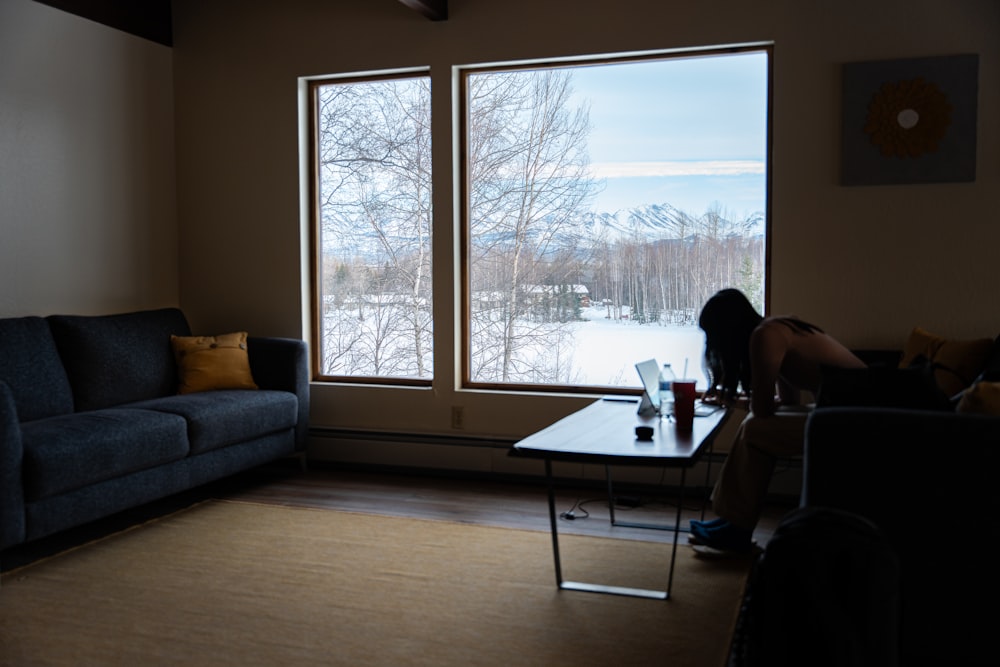 a woman sitting on a couch in front of a window