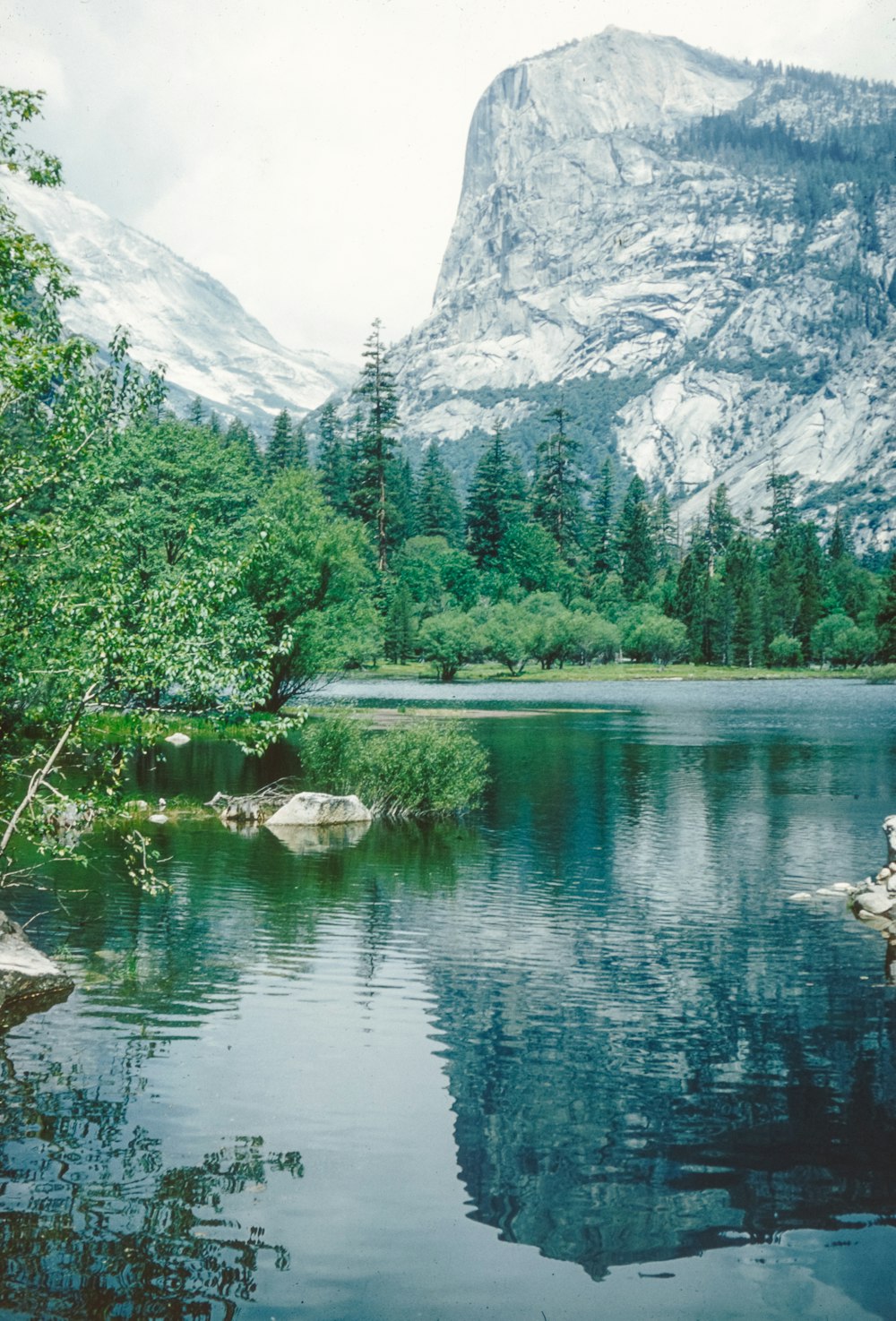 a man sitting on a rock in the middle of a lake