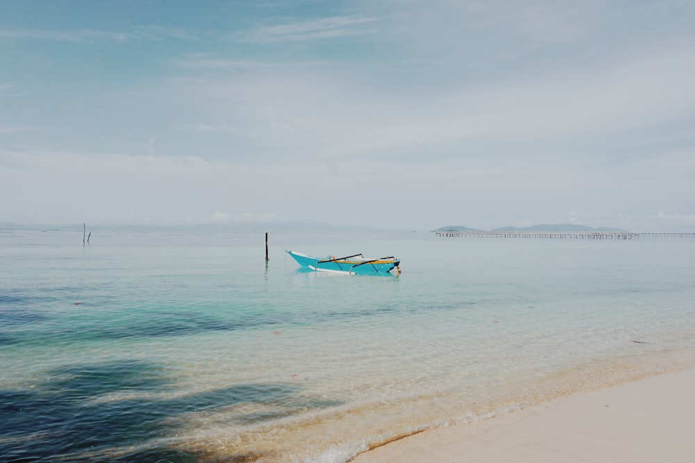 a small boat sitting on top of a sandy beach