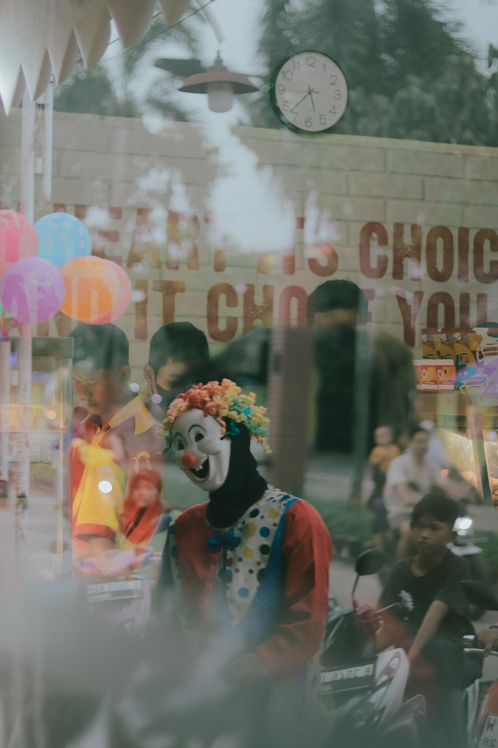 a clown with a clown mask on standing in front of a store window