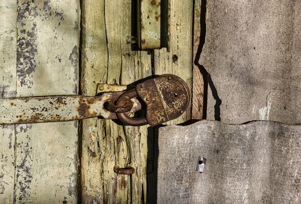 a rusted padlock on a wooden door