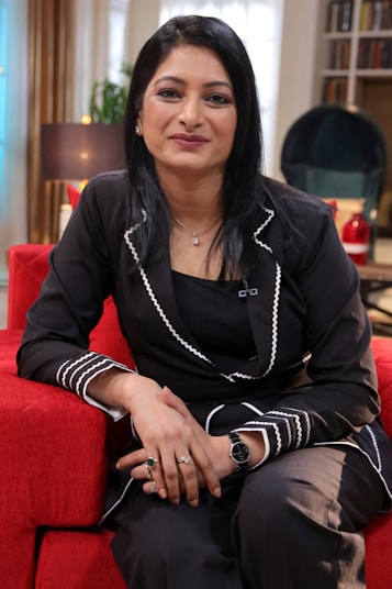 a woman sitting on top of a red couch