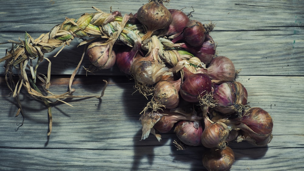 a pile of onions sitting on top of a wooden table