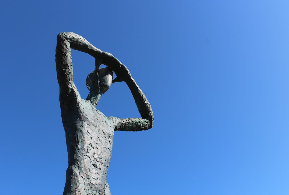 a statue of a woman holding her head in her hands