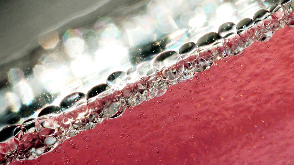 a close up of water droplets on a red surface
