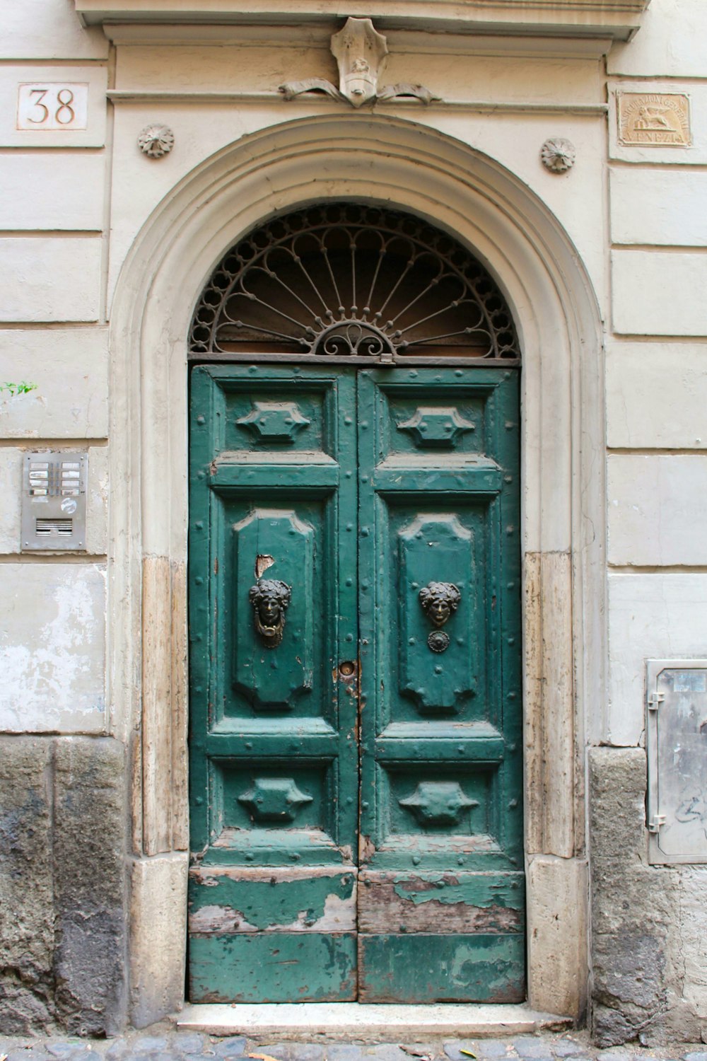 a large green door with a window above it