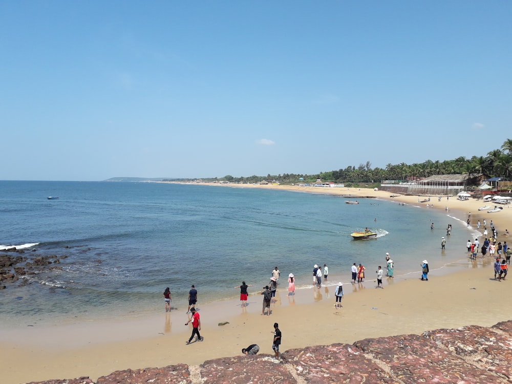 a group of people standing on top of a sandy beach