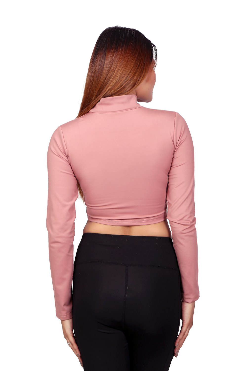 a woman wearing a pink top and black pants