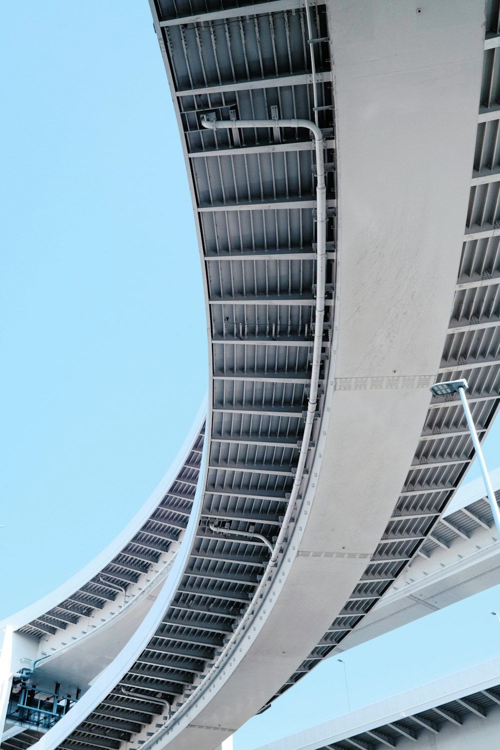 the underside of a bridge with a blue sky in the background