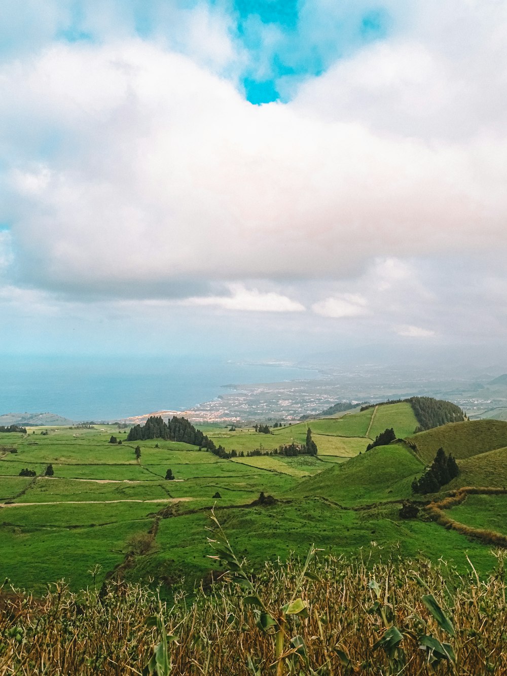 a view of a lush green countryside with a blue sky