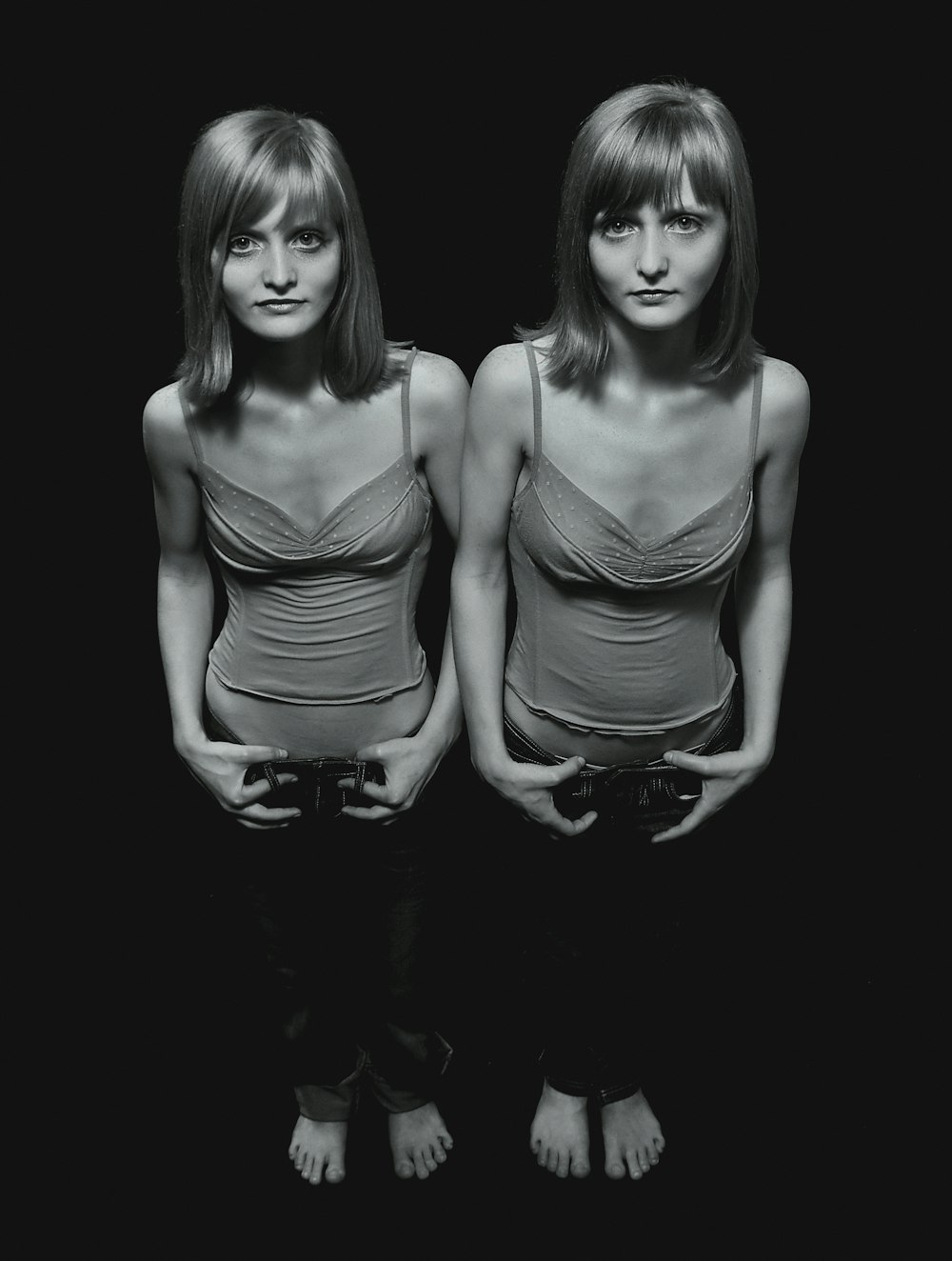 two women standing next to each other in black and white