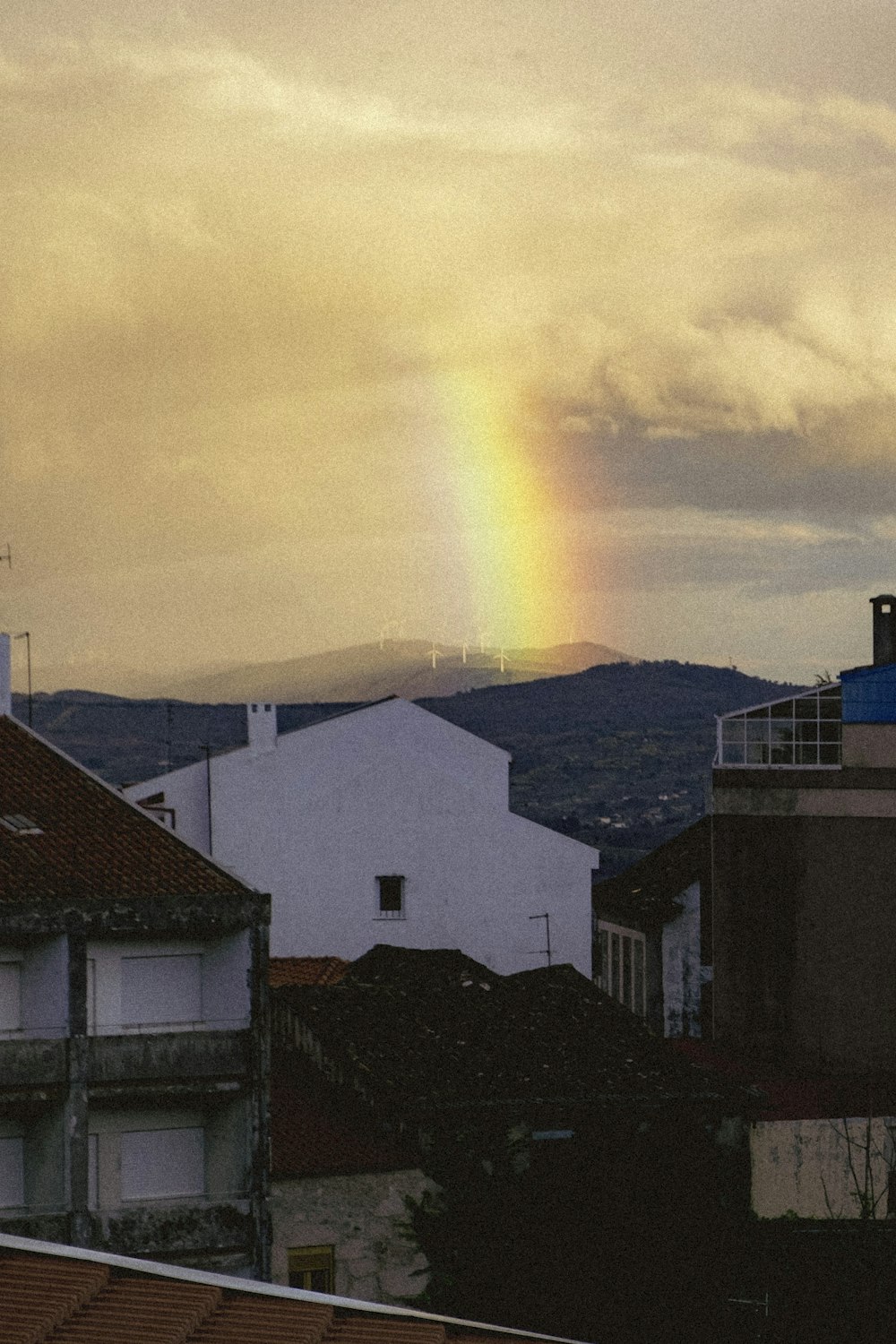 a rainbow shines in the sky over a city