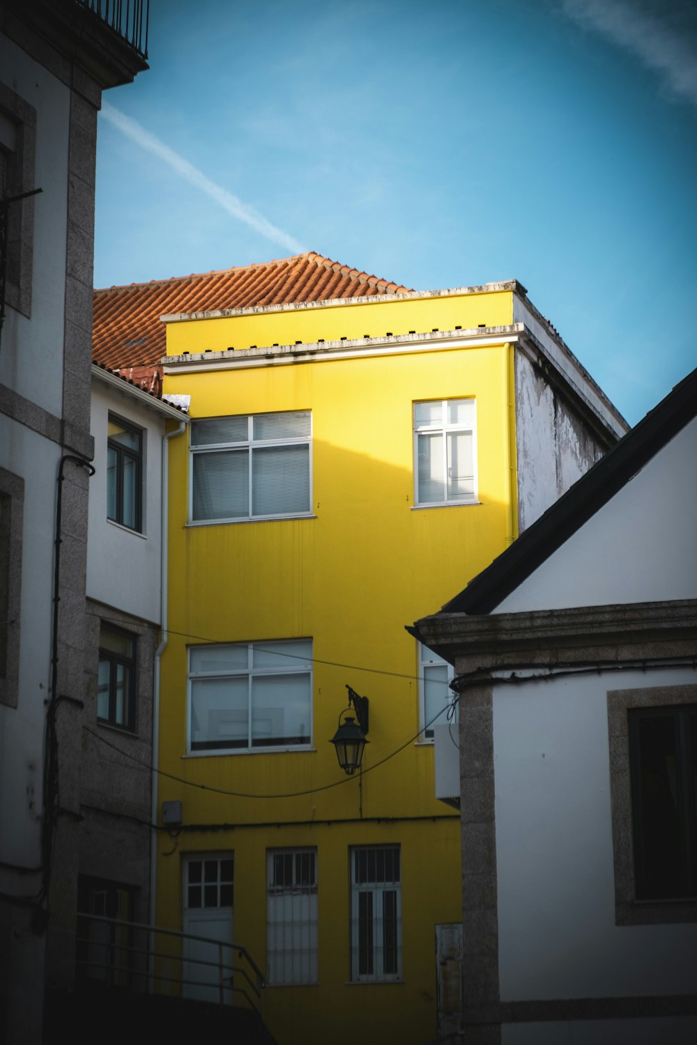 a tall yellow building with a red roof