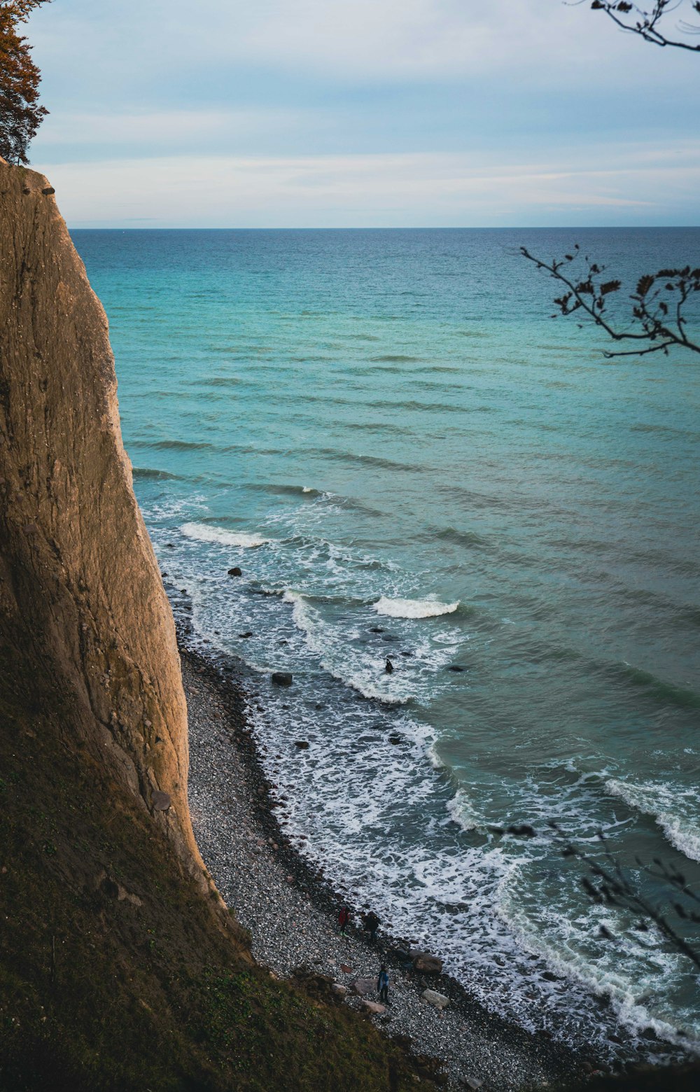 eine Person, die am Rande einer Klippe in der Nähe des Ozeans steht