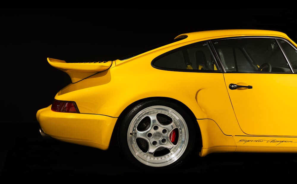 a yellow sports car parked in a dark room