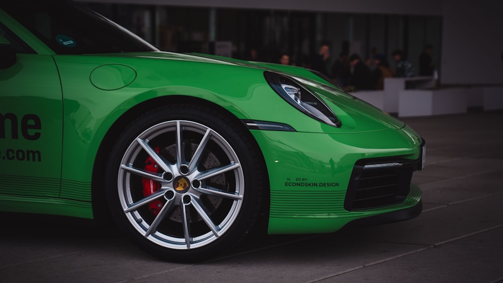 a green sports car parked in front of a building