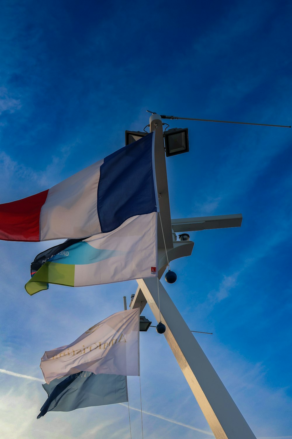 two flags flying in the wind on a sunny day