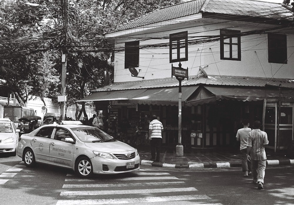 a black and white photo of a man crossing the street