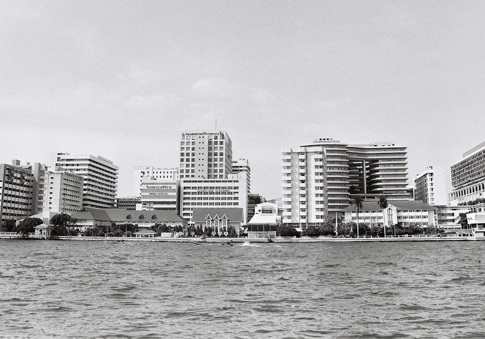 a black and white photo of a city by the water