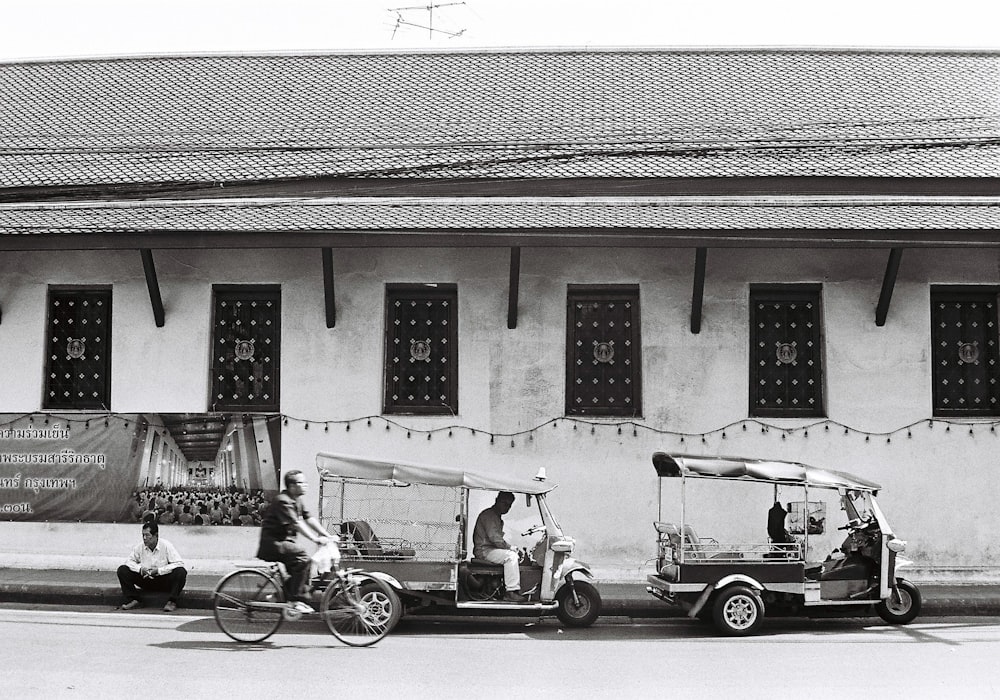 a black and white photo of three vehicles parked in front of a building