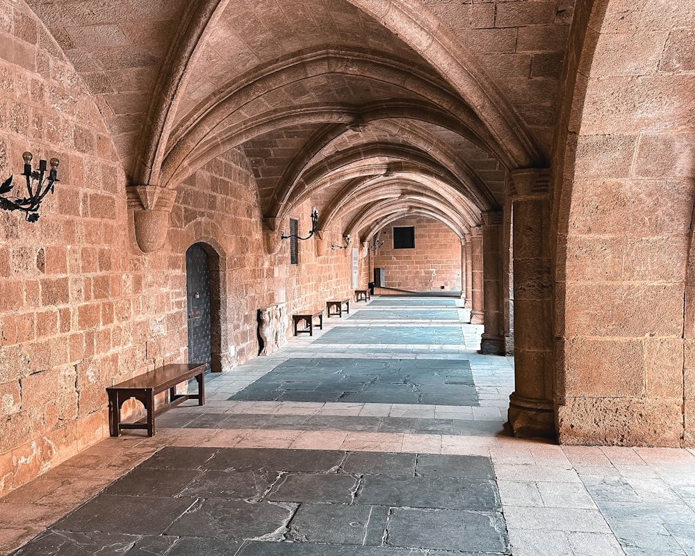 a row of benches sitting next to a stone wall