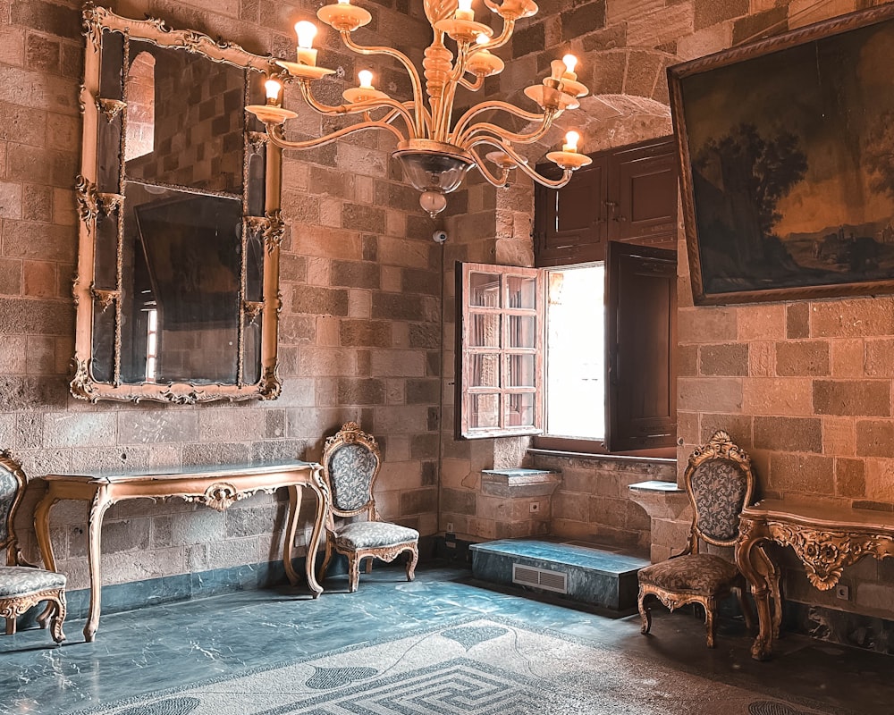 a room with a chandelier and a table and chairs