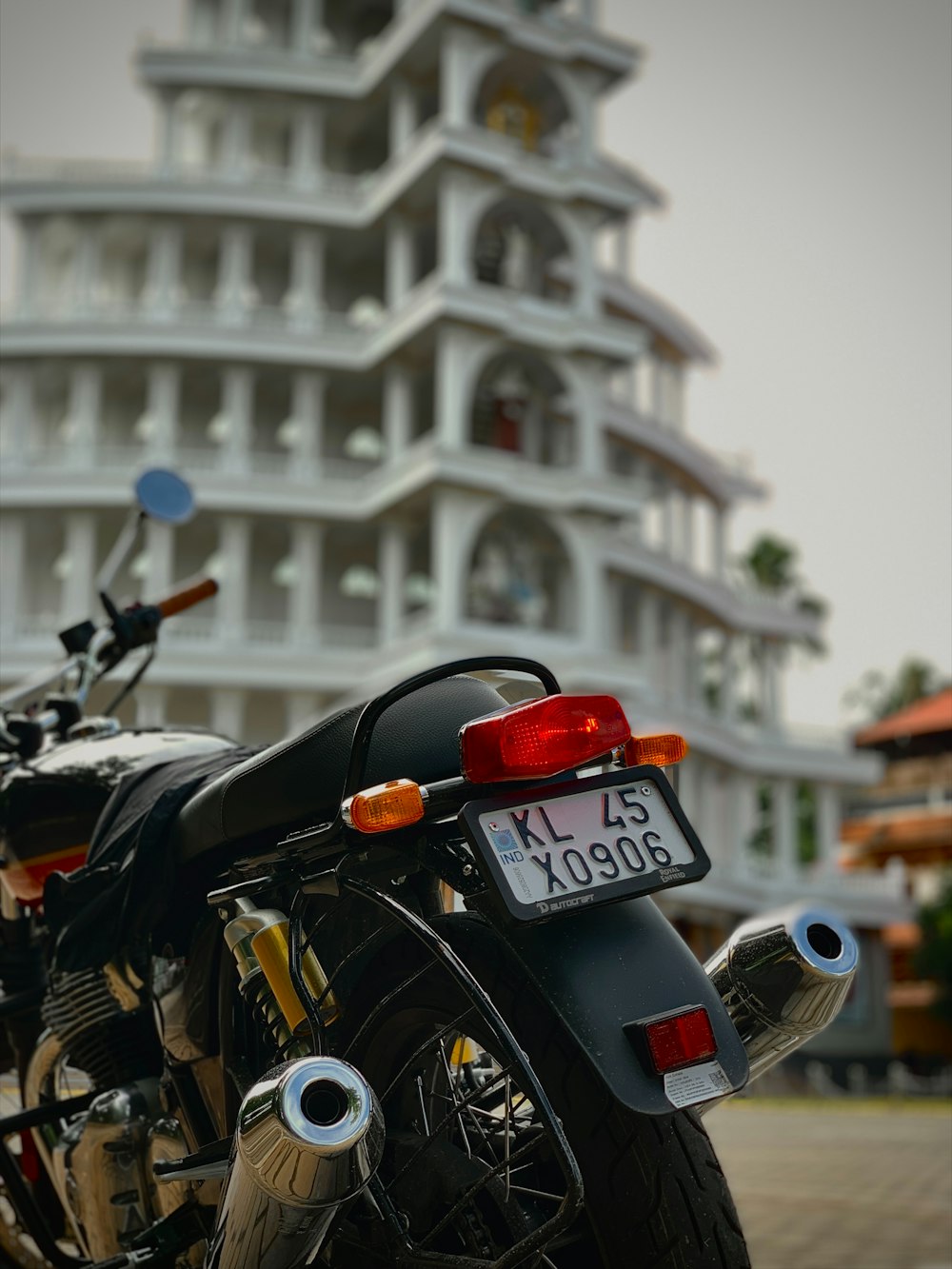 a black motorcycle parked in front of a tall building