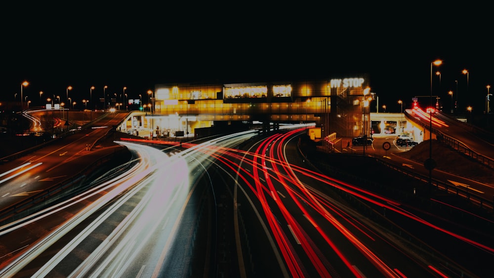 a night time picture of a highway with cars passing by