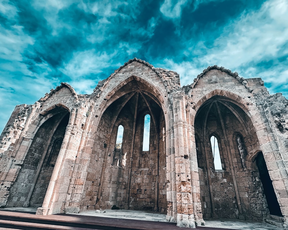 a large stone building sitting under a cloudy blue sky