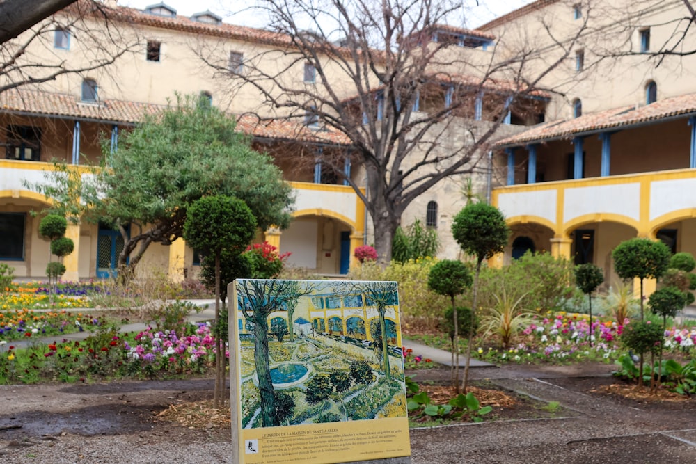 a sign in front of a building with a garden in front of it