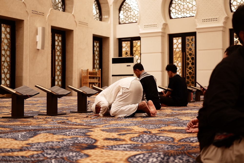 a group of men sitting on the floor of a building