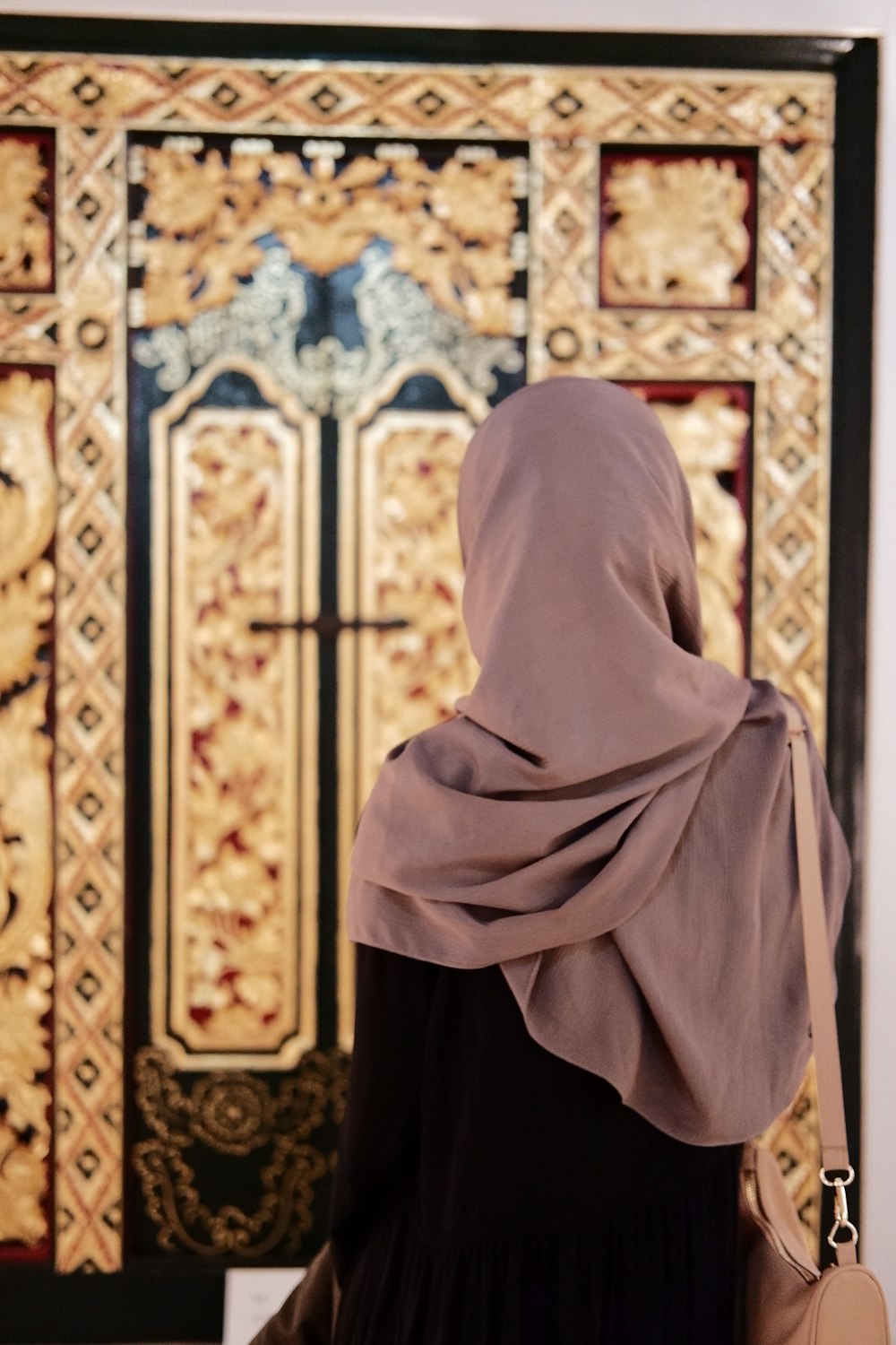 a woman in a hijab looking at a painting